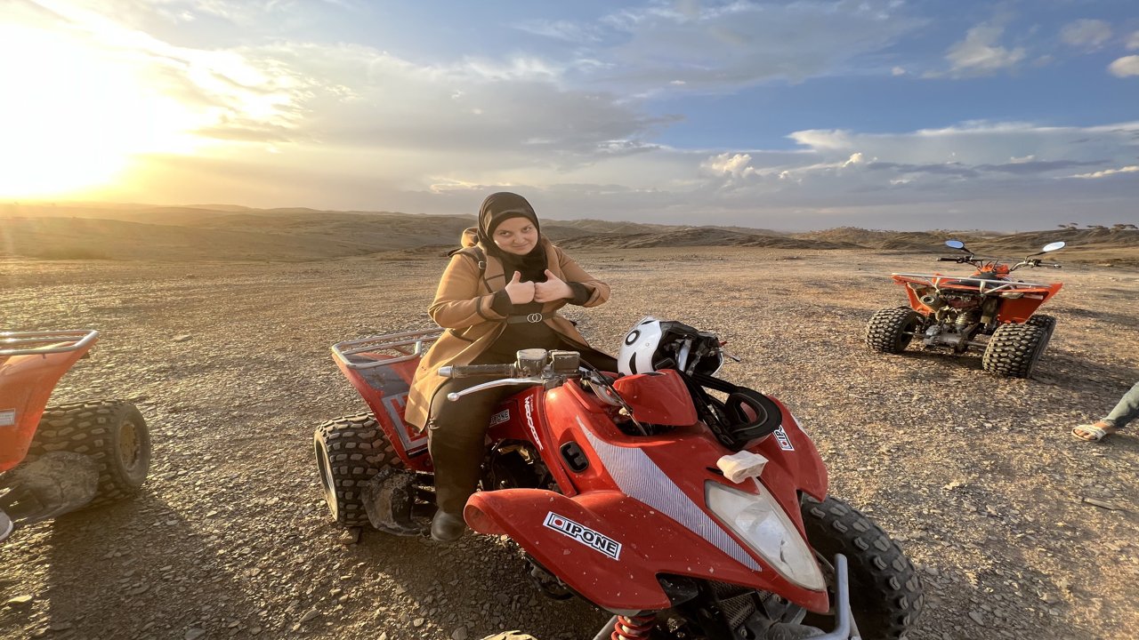 Mona is sitting on a motorsand vehicle